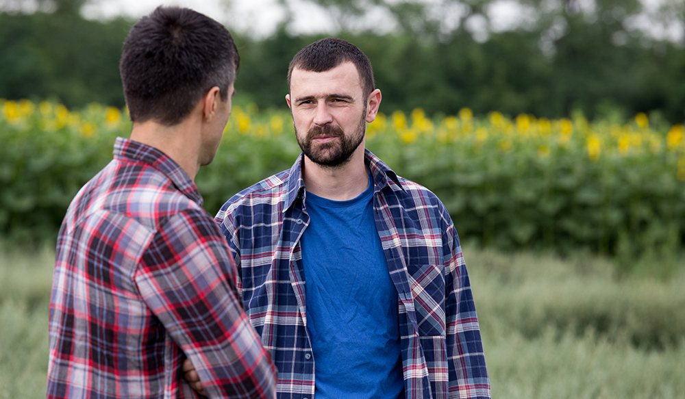 two men standing in a field
